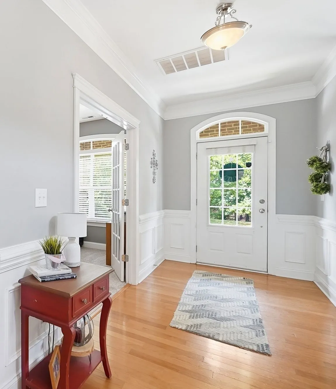 Selling 3 Bright entry with hardwood floors and white wainscoting in a home listed by the longleaf group